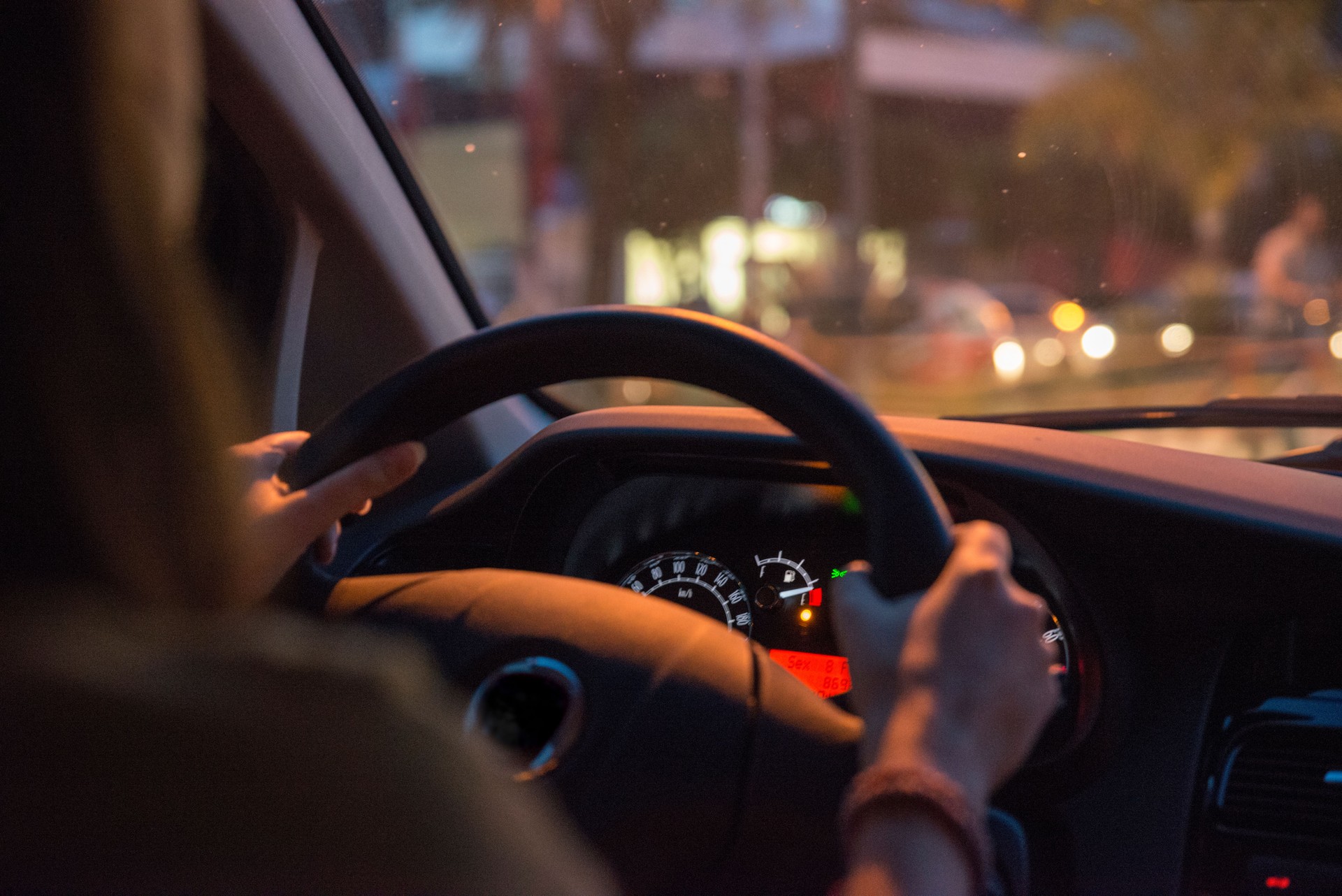 single woman drives car holding steering wheel low gas commuter